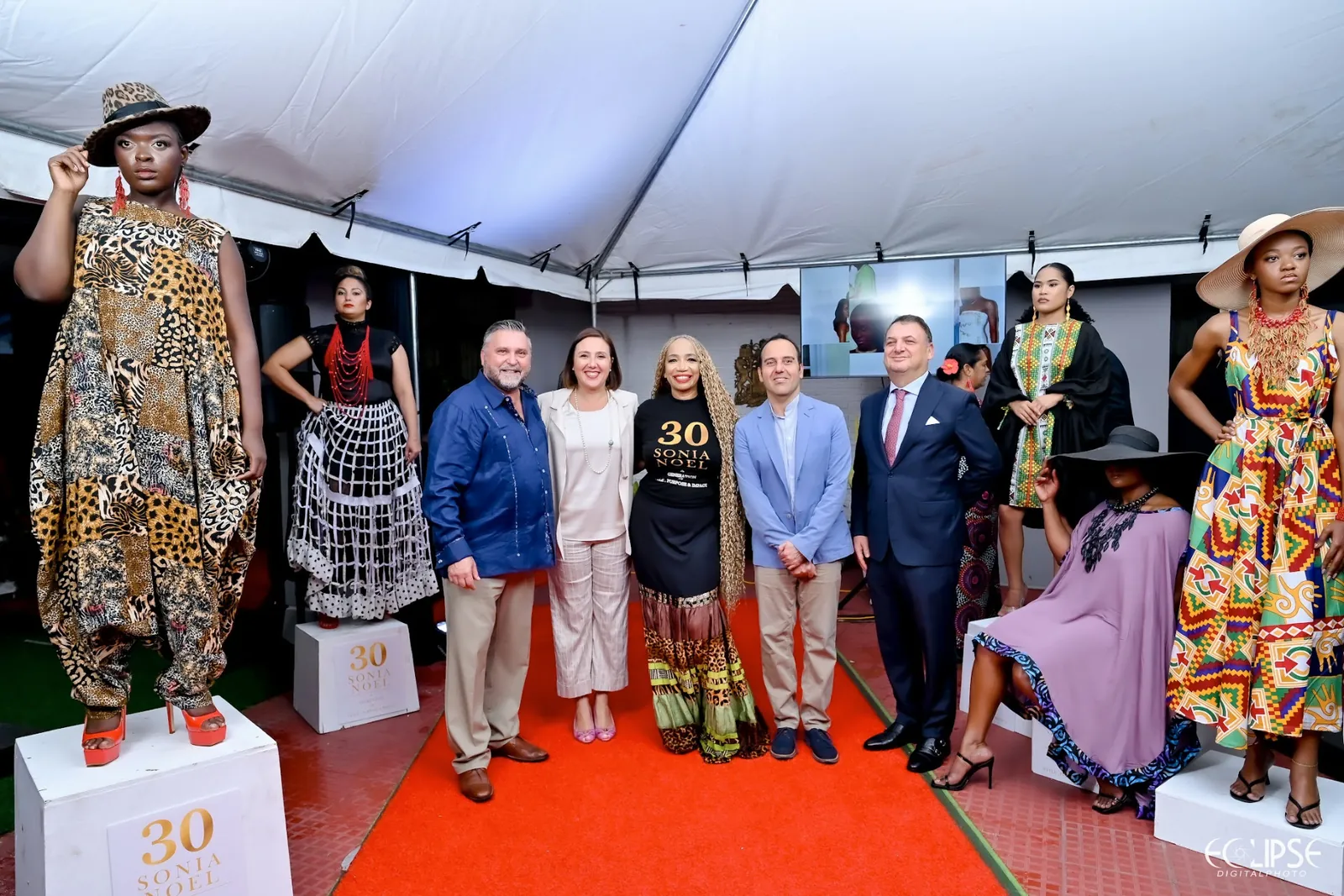 Sonia Noel and diplomatic guests posing with models showcasing 30-year collection pieces