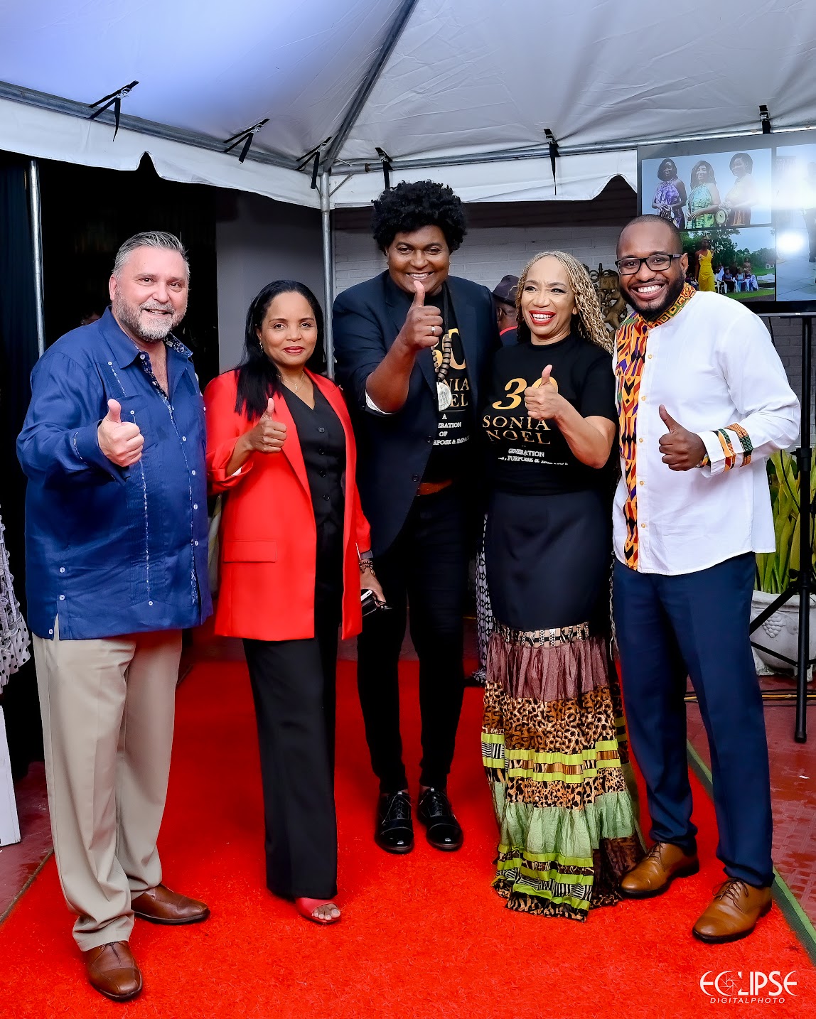 Sonia Noel with supporters and collaborators giving thumbs up on the red carpet