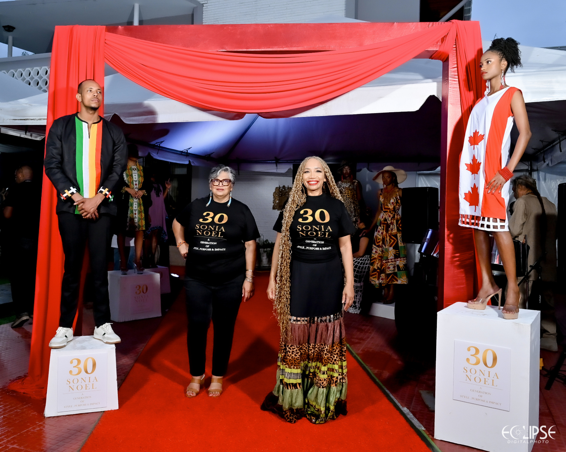 Sonia Noel with guests on the red carpet under the draped launch entrance, flanked by models on plinths
