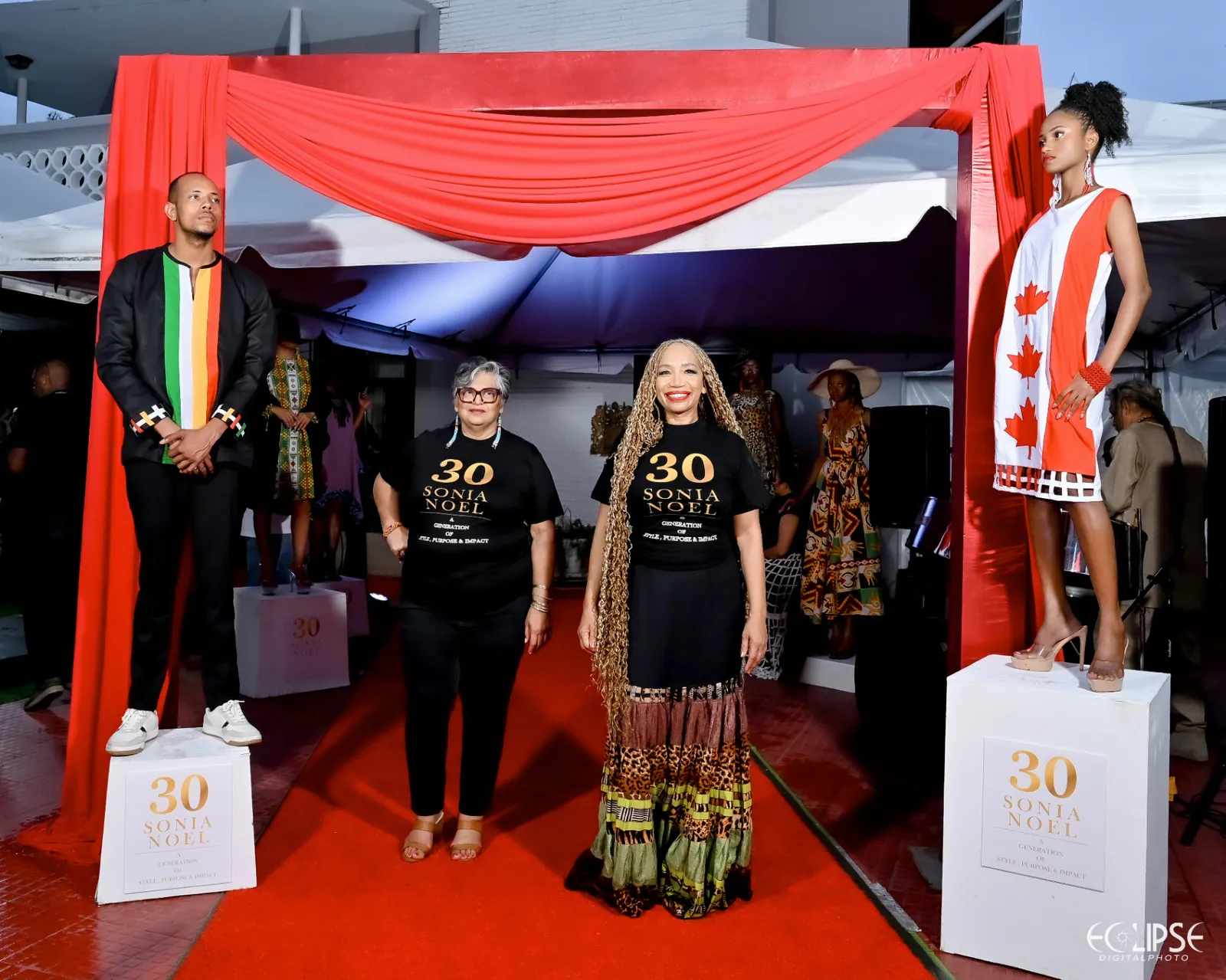 Sonia Noel with guests on the red carpet under the draped launch entrance, flanked by models on plinths