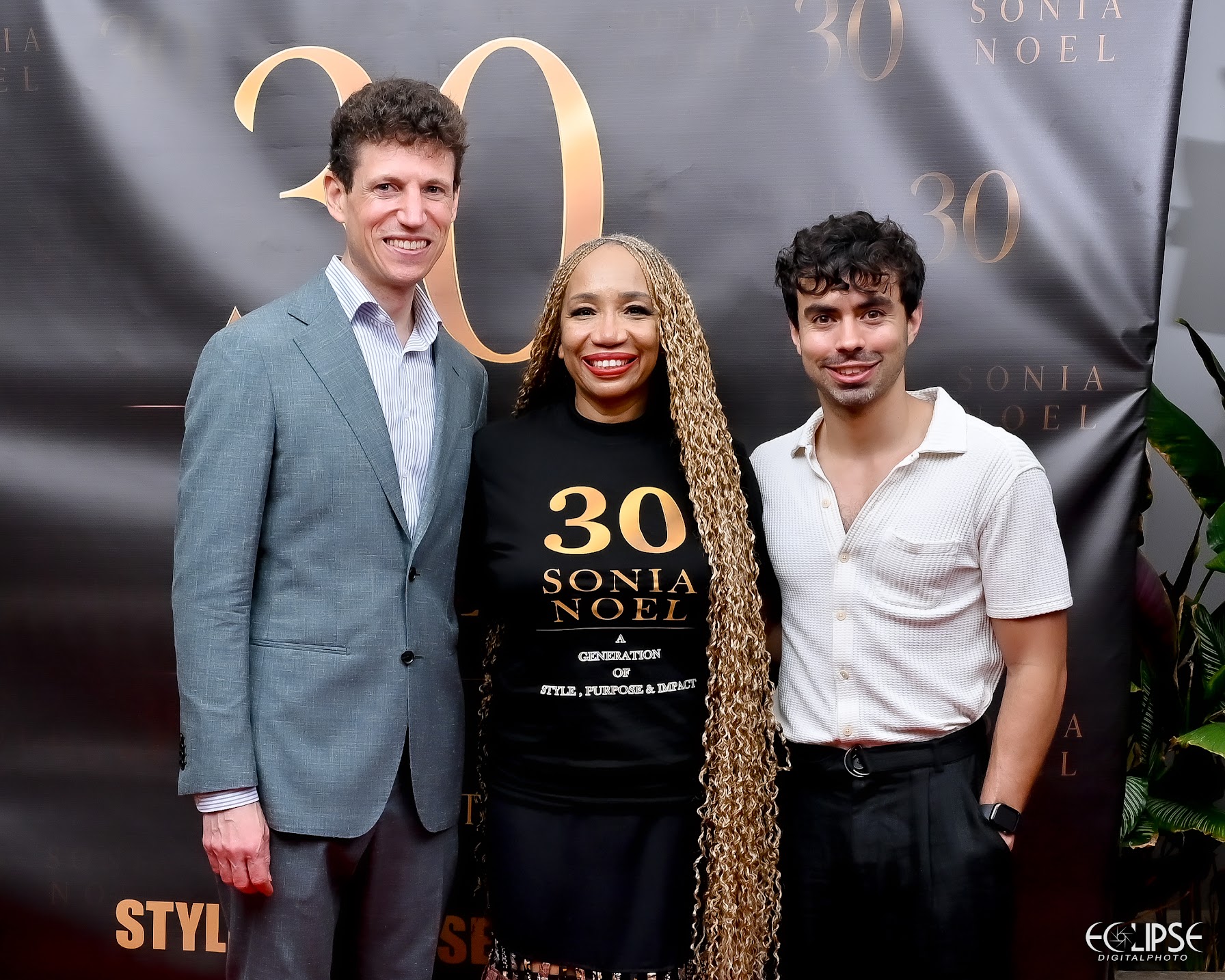 Sonia Noel with guests in front of the 30 Sonia Noel step-and-repeat backdrop